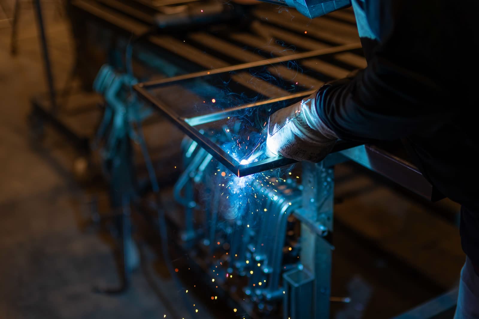 Spawacz podczas spawania stalowej konstrukcji w warsztacie METAL LAB